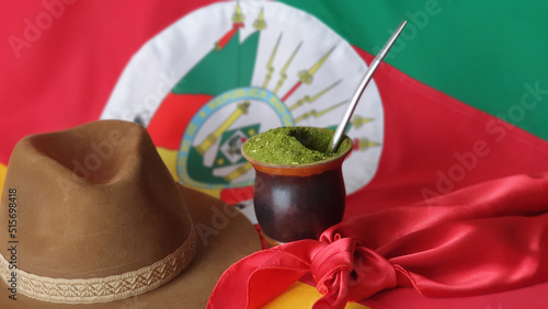 Cuadro en lienzo Hat, mate, red gaucho scarf and Rio Grande do Sul State Flag - Brazil blurred in the background