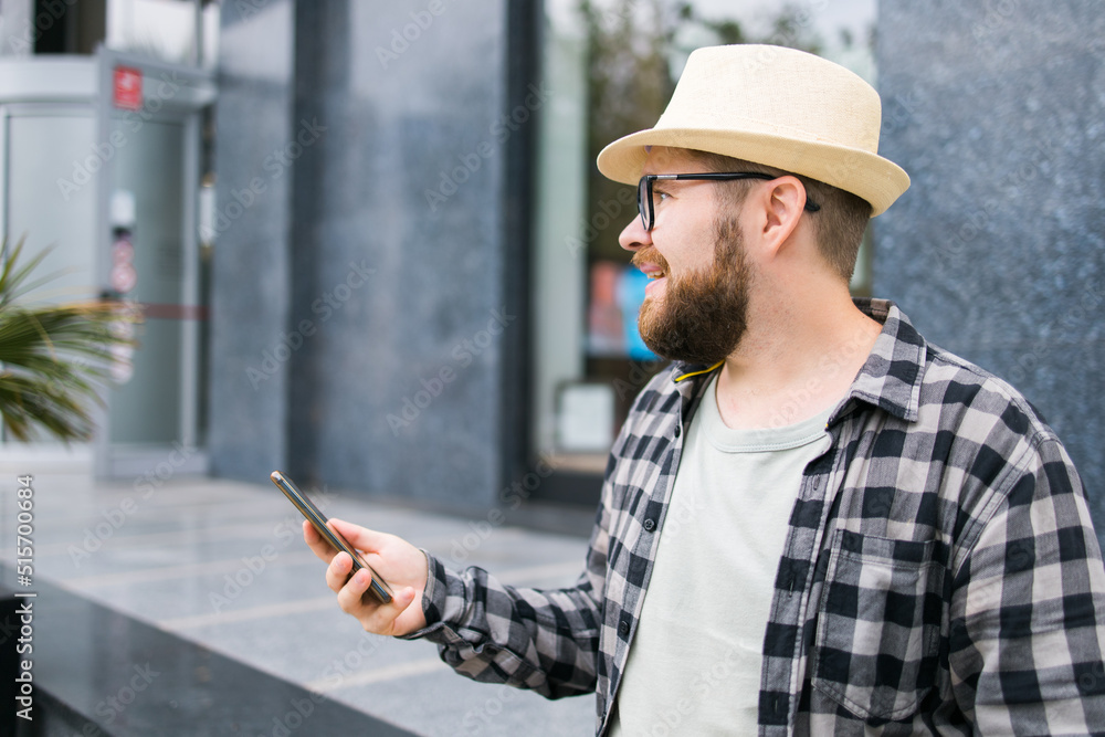 Smiling male tourist use smartphone during summer city break - technologies and social media app concept Smiling male tourist use smartphone during summer city break - technologies and social media app concept