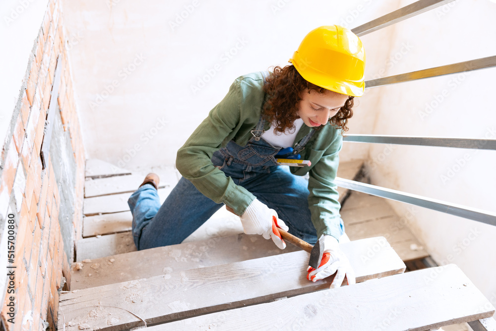 Young woman, professional builder makes room repairs using different work tools. Gender equality. Work, occupation, apartment renovation.