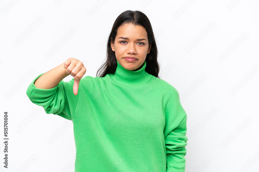 Young Colombian woman isolated on white background showing thumb down with negative expression Young Colombian woman isolated on white background showing thumb down with negative expression