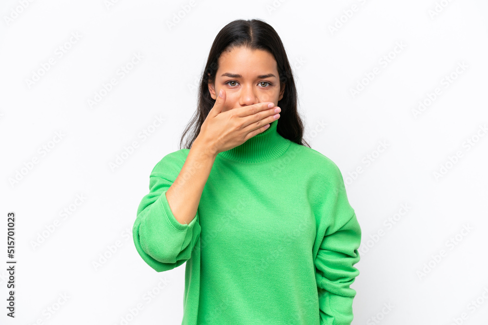 Young Colombian woman isolated on white background covering mouth with hand Young Colombian woman isolated on white background covering mouth with hand