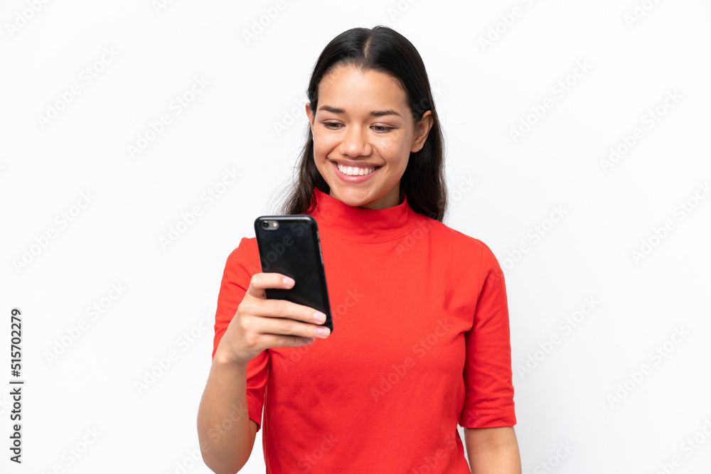 Young Colombian woman isolated on white background sending a message or email with the mobile Young Colombian woman isolated on white background sending a message or email with the mobile