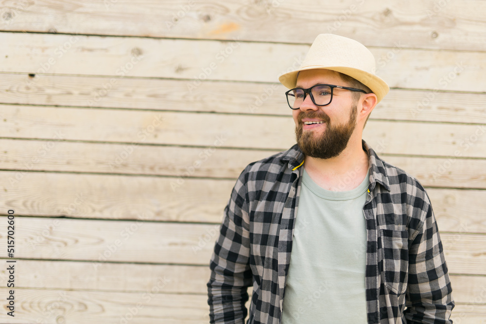 Happy man wearing hat over wooden background with copy space - vacation travel holidays concept Happy man wearing hat over wooden background with copy space - vacation travel holidays concept