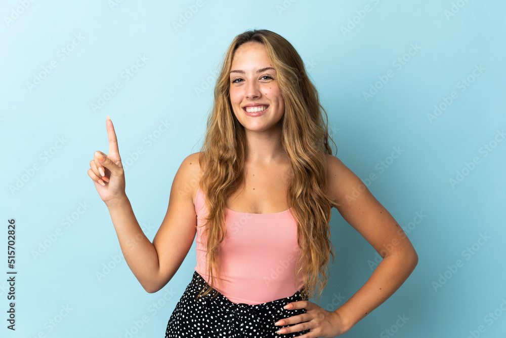 Young blonde woman isolated on blue background showing and lifting a finger in sign of the best Young blonde woman isolated on blue background showing and lifting a finger in sign of the best