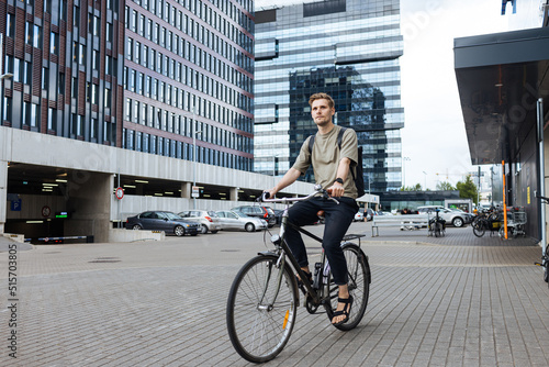 Young man riding a bike. Sustainable micro mobility transport New way of inclusive cities mobility. Green transportation. Sustainable climate neutral city goals. Green mobility and transportation