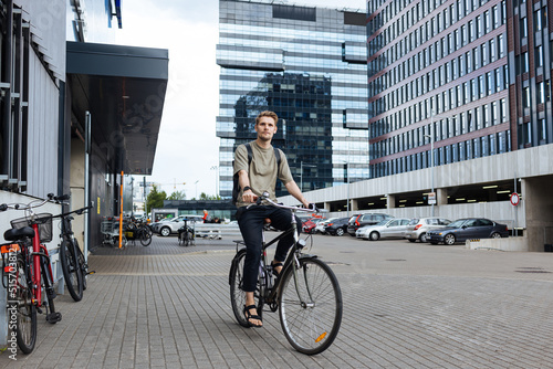 Young man riding a bike. Sustainable micro mobility transport New way of inclusive cities mobility. Green transportation. Sustainable climate neutral city goals. Green mobility and transportation