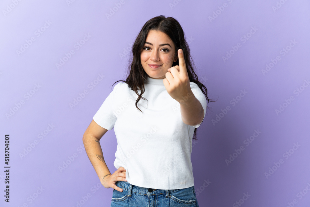 Young caucasian woman isolated on purple background doing coming gesture Young caucasian woman isolated on purple background doing coming gesture