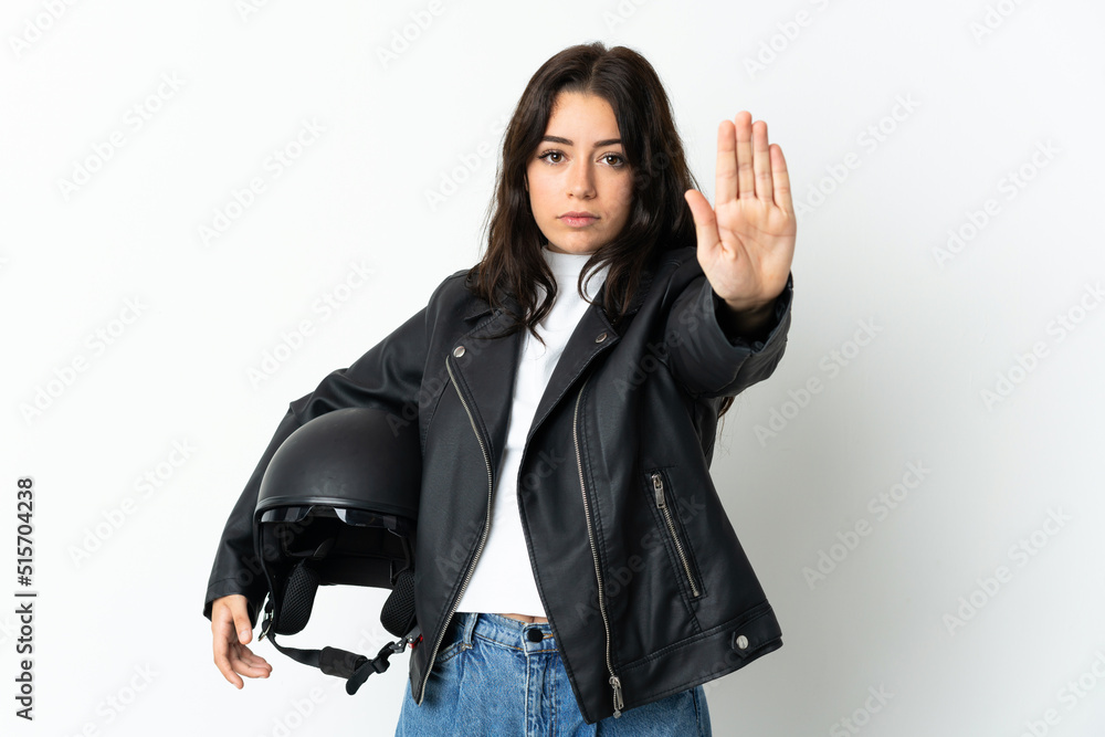 Woman holding a motorcycle helmet isolated on white background making stop gesture Woman holding a motorcycle helmet isolated on white background making stop gesture