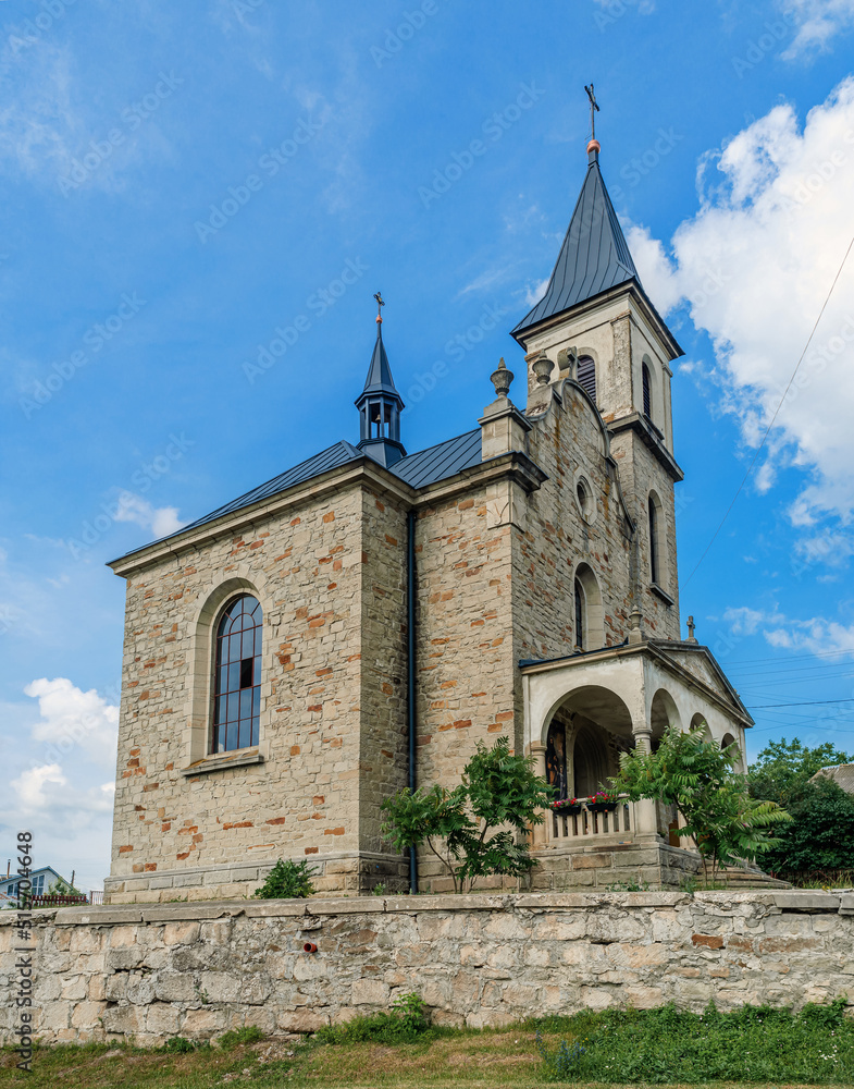 Fototapeta premium Cloudy landscape with a stone church. Catholic church on the background of a cloudy sky.