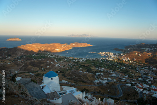 Traditional style white church with blue dome on hill in Chora town and the view over the Livadi bay on Serifos island in Greece