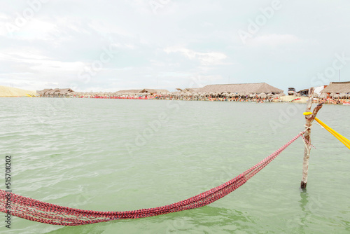 Resting in a hammock on the edge of the tatajuba lagoon in jericoacoara ceará brazil. Traditional hammock in the sea in Jeri. Rest hammock concept. vacation rest concept. photo