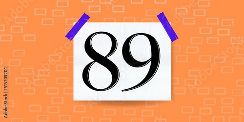 Number 89. Banner with the number eighty nine on a orange background and white square with blue stickers photo