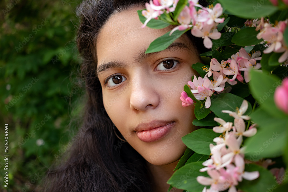 Beautiful girl on a background of pink flowers.