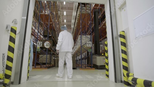 Medical factory supplies storage indoor with workers people. Young worker opening door of industrial warehouse