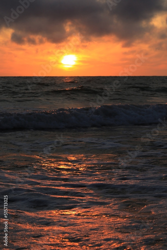 dark rainy cumulous clouds and epic sunset on the beach