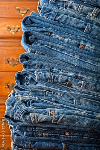 Tall stack of a denim wardrobe in front of dresser