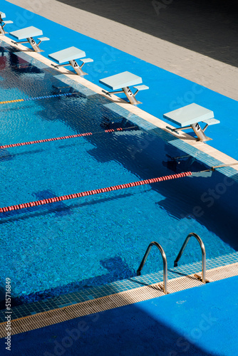 Numbered diving boards along the edge of a competitive swimming pool with swimming lanes