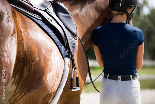 Woman standing next to tacked up horse