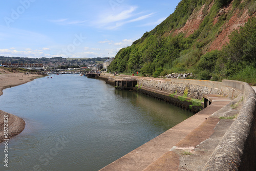 The river Axe flows quickly as it travels towards the sea looking back towards the marina and the yacht club