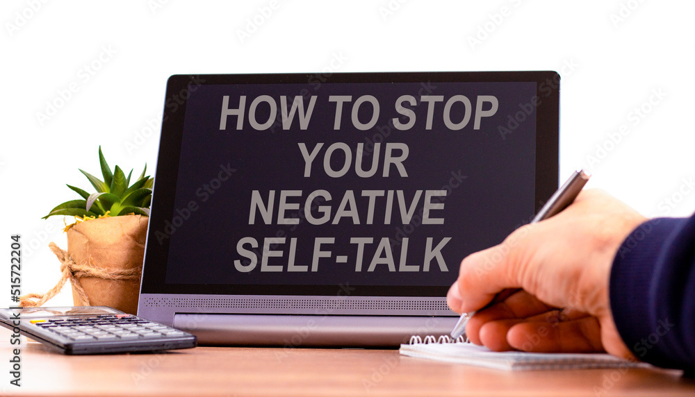 Stop negative self-talk symbol. Concept words How to stop your negative self-talk on the black tablet. Businessman hand with pen. Psychological stop negative self-talk concept. Copy space. Stop negative self-talk symbol. Concept words How to stop your negative self-talk on the black tablet. Businessman hand with pen. Psychological stop negative self-talk concept. Copy space.