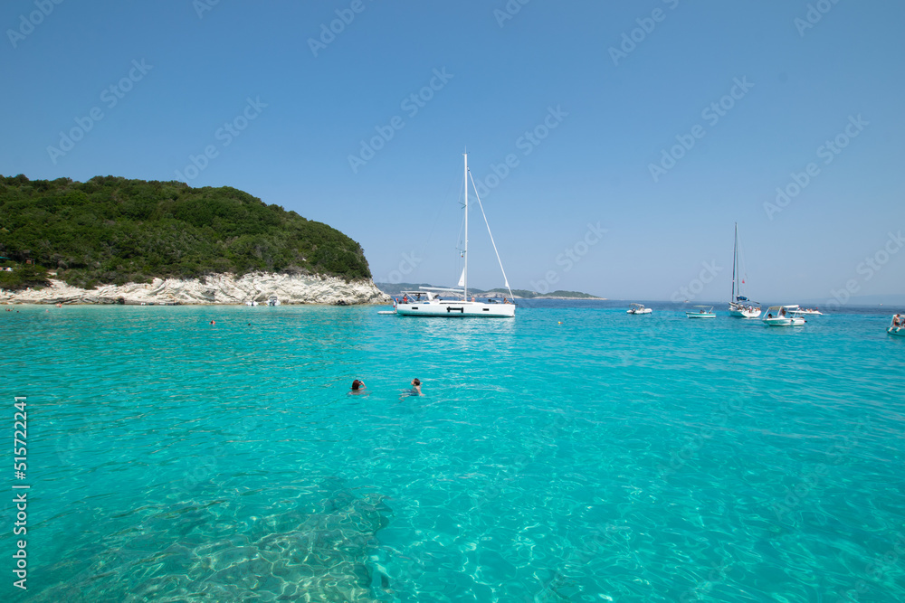 Turquoise exotic sea with sailing boats at Paxos island in Greece