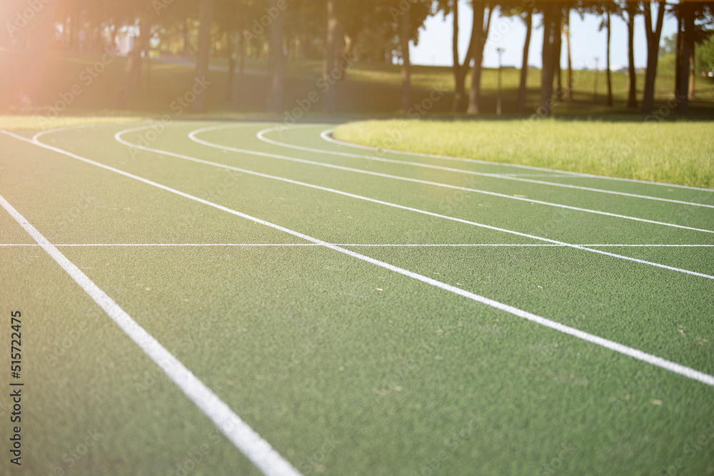 Running track at the stadium. Rubber coated green. Running track in the park outdoors, summer