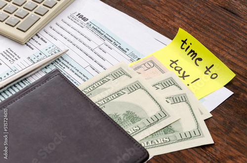 1040 US individual tax form, calculator, dollars, pen and yellow sticker