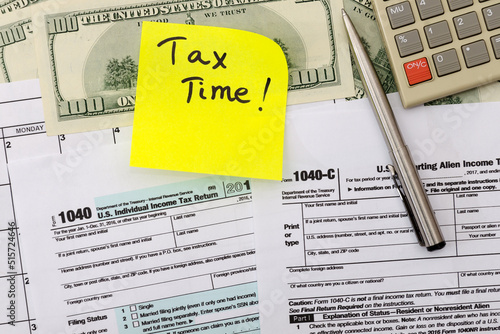 1040 US individual tax form, calculator, dollars, pen and yellow sticker
