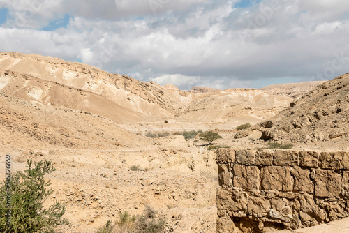 ancient above ground Nabatean cistern on the Spice Route in the Negev in Israel with the Metsad Nekarot fortress in the background under a cloudy sky