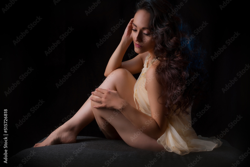 Latin woman in lingerie, with a black background, low key photography with punctual light. Latin woman in lingerie, with a black background, low key photography with punctual light.
