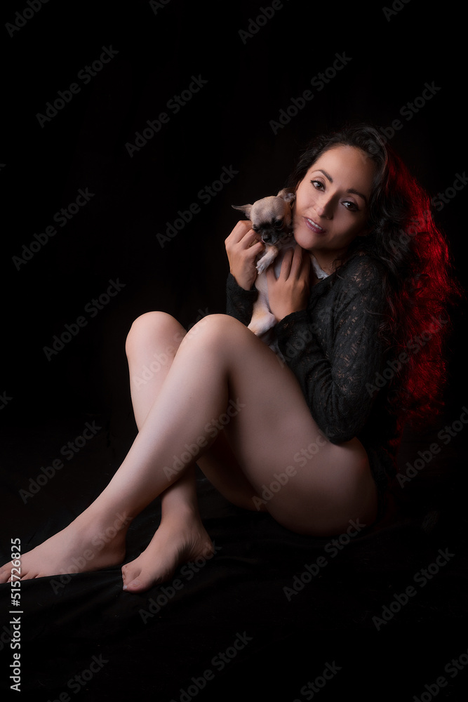 Latina woman in black lingerie, black background, low key photography with spot light. Latina woman in black lingerie, black background, low key photography with spot light.