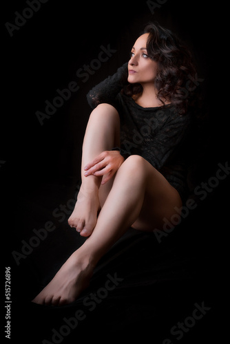 Latina woman in black lingerie, black background, low key photography with spot light. © Alfredo Hernández