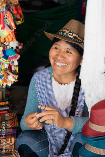 Latin woman smiling and weaving with wool in a typical souvenir shop