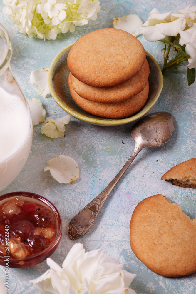 Gooseberry and walnut jam in a glass vase, homemade cookies. Milk, flowers, turquoise background, tea old spoon Gooseberry and walnut jam in a glass vase, homemade cookies. Milk, flowers, turquoise background, tea old spoon
