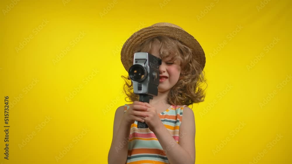 Curly girl cinematographer in hat is using retro camcorder for shooting video Curly girl cinematographer in hat is using retro camcorder for shooting video
