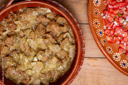 Chicharrones in green sauce, typical Mexican food. Meal served in a clay pot. photo