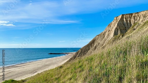 cliffs at Bovbjerg Fyr on strand, the ocean and North Sea at a sunny summer evening, Denmark, Jutland, breakwater