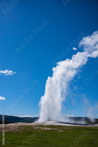 Visitors watch the famous geyser Old Faithful on a sunny day at Yellowstone National Park, which is the first national park in the U.S.
