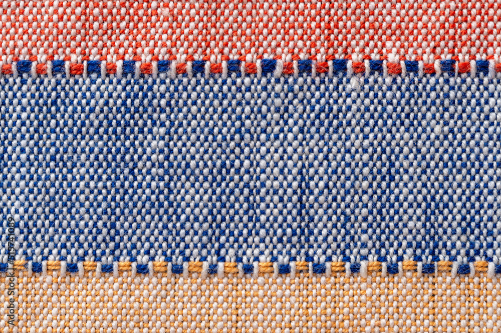 Plain weave fabric macro background. Textile with horizontal strips of red, blue, yellow colors. Detail of cloth texture surface. Weft and warp. Colorful woven fabric for design element. Plain weave fabric macro background. Textile with horizontal strips of red, blue, yellow colors. Detail of cloth texture surface. Weft and warp. Colorful woven fabric for design element.