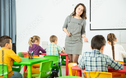 Female teacher and pupils working in classroom at elementary school. High quality photo