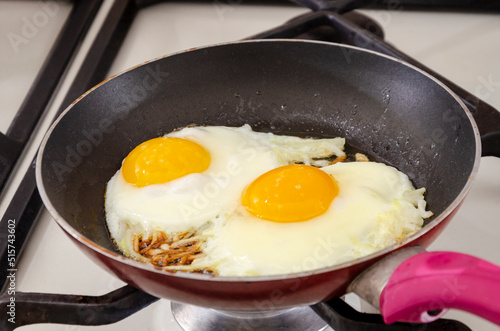 Fried eggs with onions in a pan. Close-up