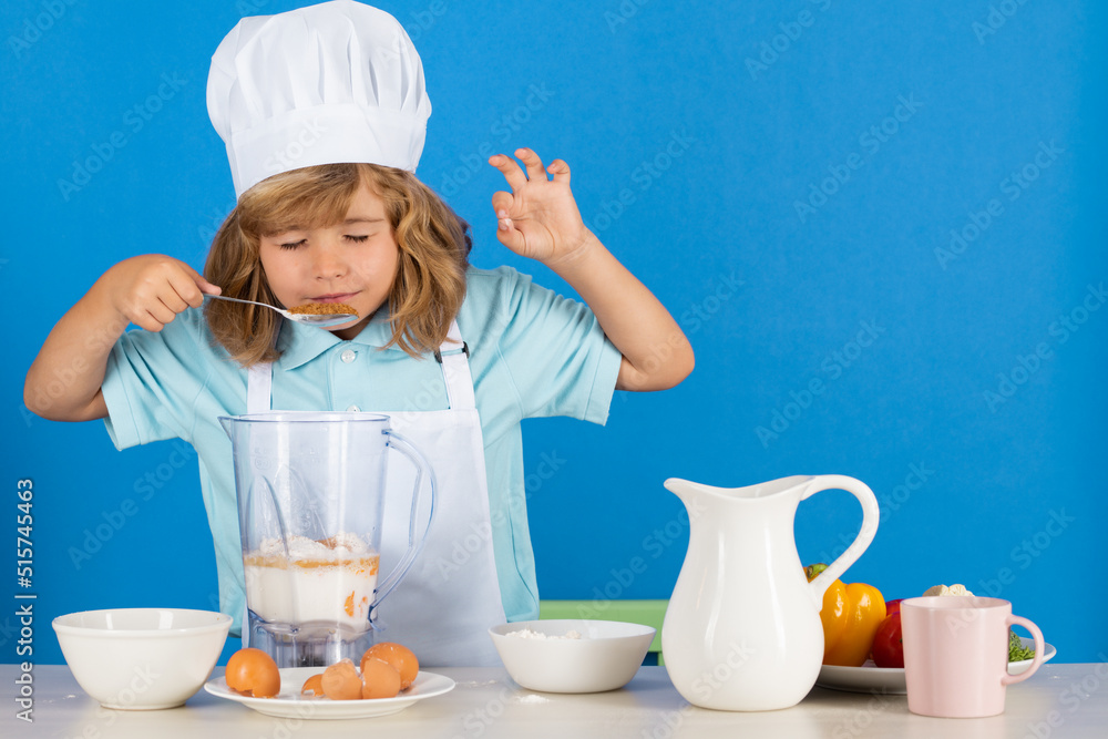 Cooking children. Chef kid boy making fresh vegetables for healthy eat. Portrait of little child in form of cook isolated on blue background. Kid chef. Cooking process. Cooking children. Chef kid boy making fresh vegetables for healthy eat. Portrait of little child in form of cook isolated on blue background. Kid chef. Cooking process.