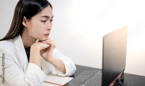 Asian young feeling stress from work, while sitting in front of the laptop in their home.