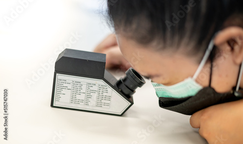 The Gemologist examing the precious stone with the refractometer to separate ohe type of stone. photo