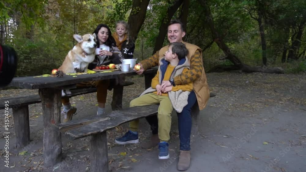 Happy family having picnic on autumn day with dog Happy family having picnic on autumn day with dog