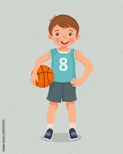 cute little boy with sportswear holding basketball standing posing with hand on his waist