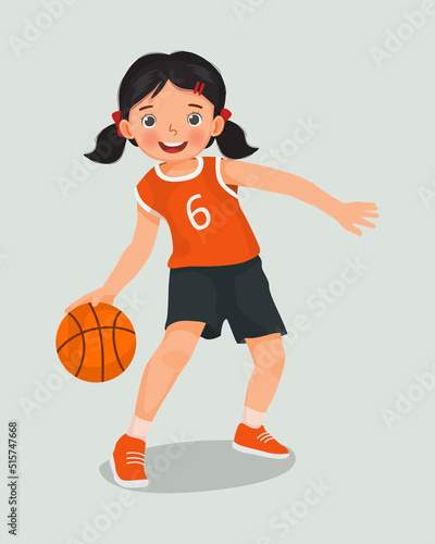 cute little girl with sportswear playing basketball dribbling the ball in action