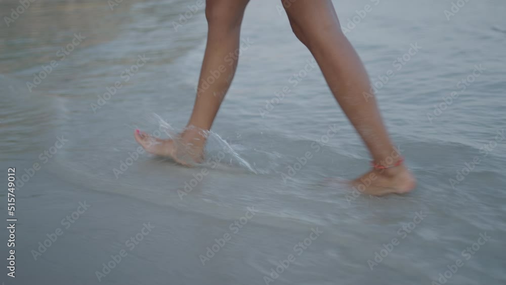 Social media woman blogger vlogging on a beach walking by the sea with a phone on selfie stick