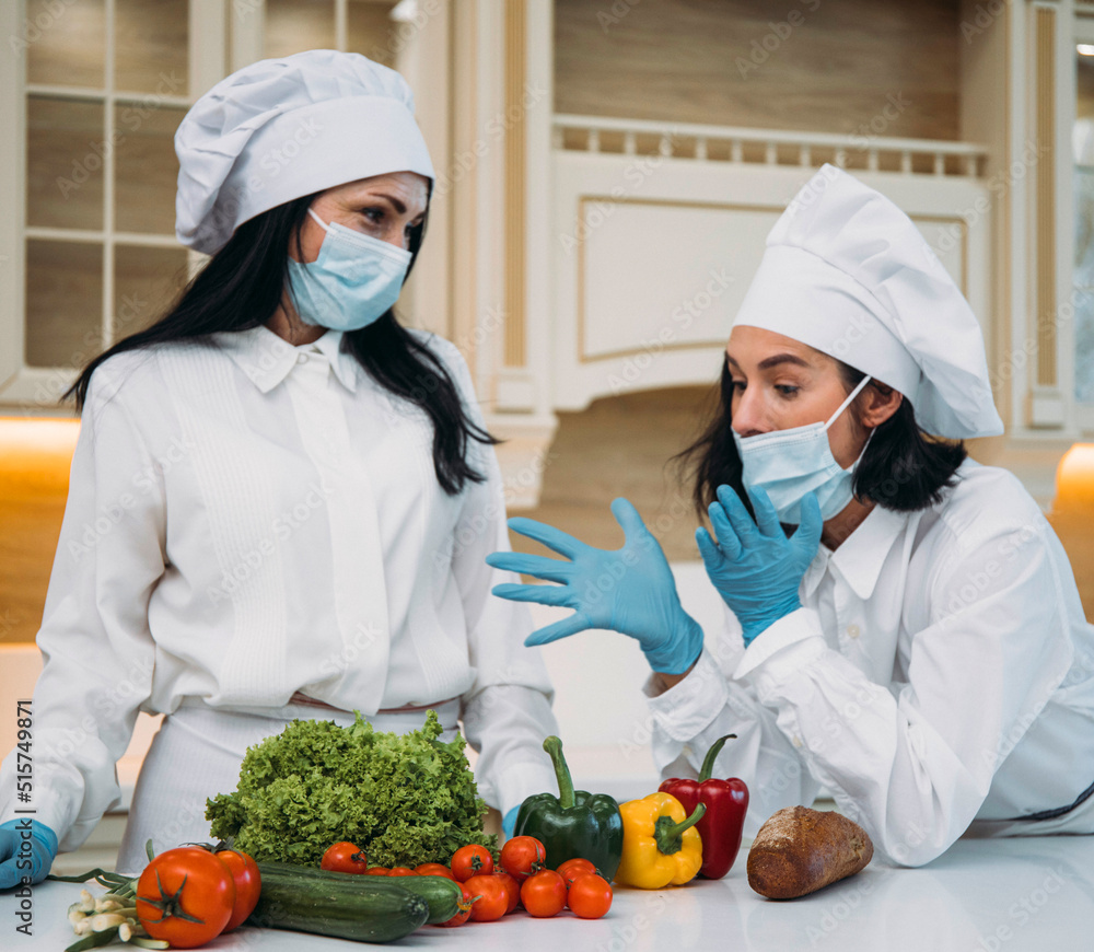 two woman in the kitchen. Kitchen. Happy day. Vegetarian. Pandemic. Mask face. Diet. two woman in the kitchen. Kitchen. Happy day. Vegetarian. Pandemic. Mask face. Diet.