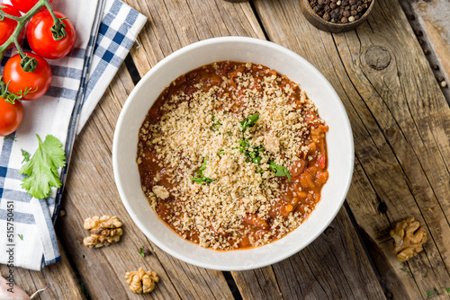 bean lobio in a pot megrelian with walnuts top view on wooden table photo